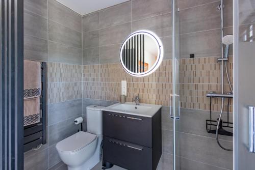 une salle de bain avec toilettes, lavabo et miroir dans l'établissement Parenthèse idéale Chambre J double dans villa face mer Carnac, à Carnac