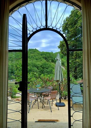 an open door to a patio with a table and chairs at Font Neuve in Souillac