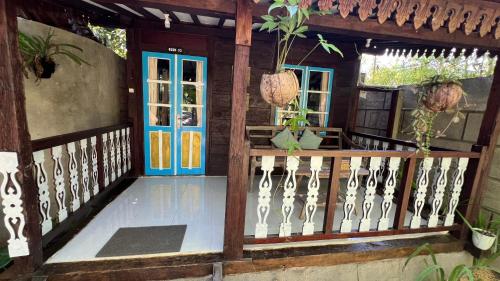 a porch of a house with a blue door at Tahlia's Villa in Sorongjukung