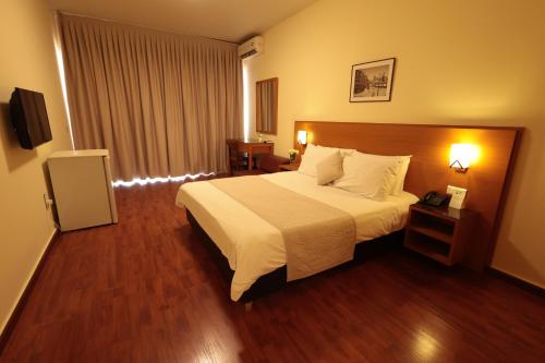 a hotel room with a bed and a television at Monteverde Hotel in Beit Meri