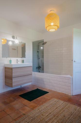 une salle de bain avec un lavabo et un miroir dans l'établissement Le Gîte de la Verrerie, maison traditionnelle avec piscine, à Eygurande-et-Gardedeuil
