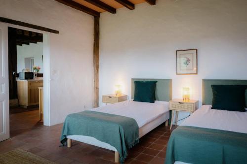 Ένα ή περισσότερα κρεβάτια σε δωμάτιο στο Le Gîte de la Verrerie, maison traditionnelle avec piscine