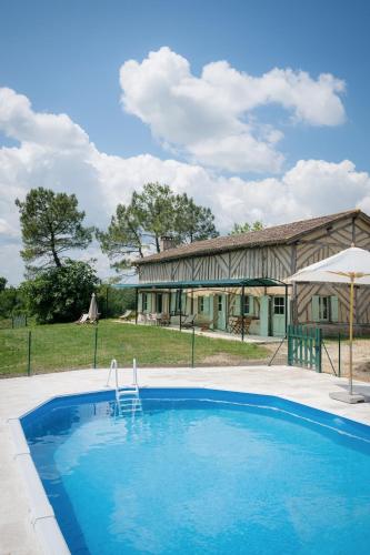 une grande piscine devant une maison dans l'établissement Le Gîte de la Verrerie, maison traditionnelle avec piscine, à Eygurande-et-Gardedeuil