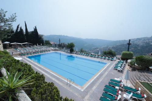 a large swimming pool with chaise lounge chairs at Monteverde Hotel in Beit Meri
