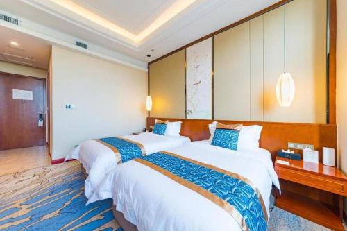 a hotel room with two beds in a room at YUN-RAY Hotel Shijiazhuang in Shijiazhuang