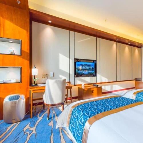 a hotel room with a large bed and a desk at YUN-RAY Hotel Shijiazhuang in Shijiazhuang