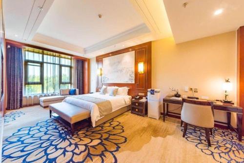 a hotel room with a bed and a desk and a bed sidx sidx at YUN-RAY Hotel Shijiazhuang in Shijiazhuang