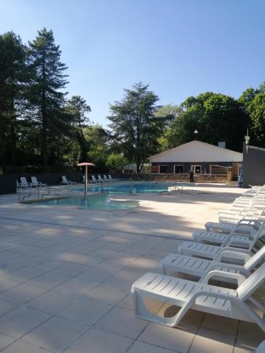 - une rangée de chaises longues blanches installées à côté de la piscine dans l'établissement La Margotine, à Camiers