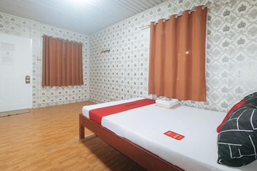 a small room with a bed and a window at RedDoorz @ Boondocks Cabins Resort in Dalumpinas Oeste