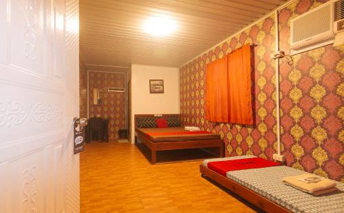 a room with a bed and a couch in it at RedDoorz @ Boondocks Cabins Resort in Dalumpinas Oeste
