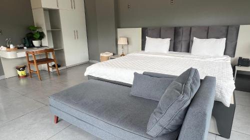 a bedroom with a large bed and a couch at Lotus Premium Lodge - Lotus Group Tours in Ha Giang