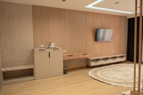 a room with a table and a television on a wall at Imran Palace Hotel in Namangan