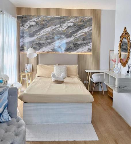 a bedroom with a bed and a painting on the wall at Mesatierra Garden Residences in Davao City