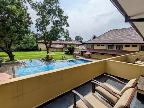 a view of a swimming pool from the balcony of a house at Rajarata Hotel Anuradhapura in Anuradhapura