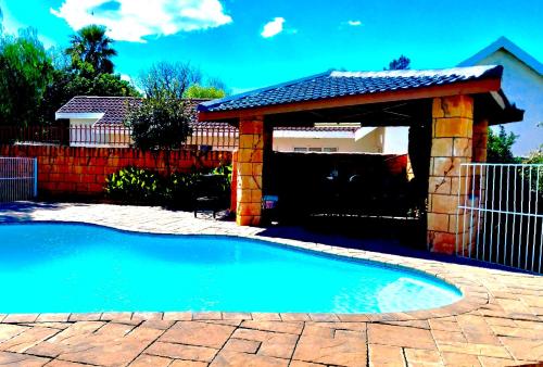 a swimming pool with a gazebo in a yard at Midway Overnight Rooms in Kimberley