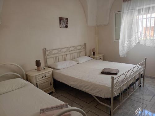 a bedroom with two twin beds and a window at casa gialla mare del salento in Maruggio