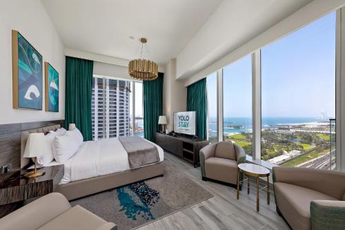a bedroom with a bed and a couch and a tv at Fabulous 2BR Apartment with Palm View in Media City in Dubai