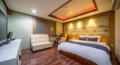 a bedroom with a bed and a desk and a television at SKY Hotel in Changwon