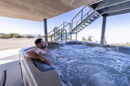 un homme allongé dans un jacuzzi dans l'établissement Secluded Dream Home with Hot Tub and Full Gym on 20 Acres, à Palomar Mountain