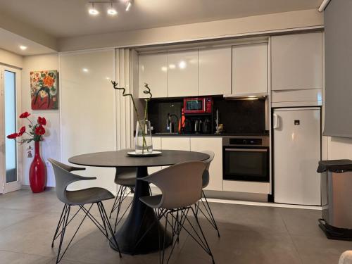 une cuisine avec une table et des chaises dans une pièce dans l'établissement Cannes, Mougins, Sophia-Antipolis, Grasse, Nice, Monaco, Saint-Tropez, à Mougins