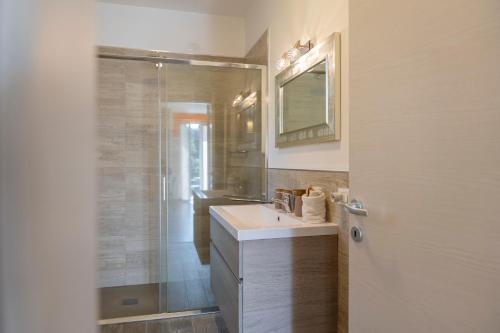 a bathroom with a shower and a sink and a mirror at Agrifoglio in Baveno