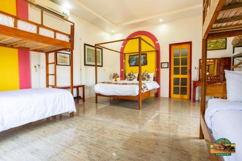 a bedroom with two beds and a mirror at Phong Nha Farmstay in Phong Nha