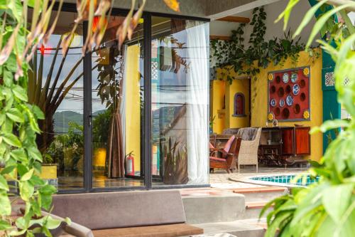 a house with yellow walls and windows and a patio at Phong Nha Farmstay in Phong Nha