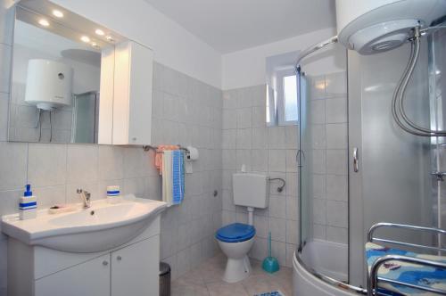 y baño con lavabo, aseo y ducha. en Apartment Fjaka en Sali