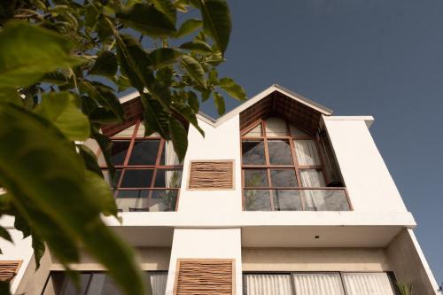 a white house with windows and a tree at The Iggy Hotel Seseh Loft 7 Sauna Ice Bath in Cemagi
