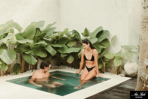 a man and a woman in a hot tub at The Iggy Hotel Seseh Loft 7 Sauna Ice Bath in Cemagi