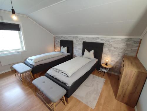a bedroom with two beds and a brick wall at Villa Björklund - Lakeview Apartment in Arjeplog
