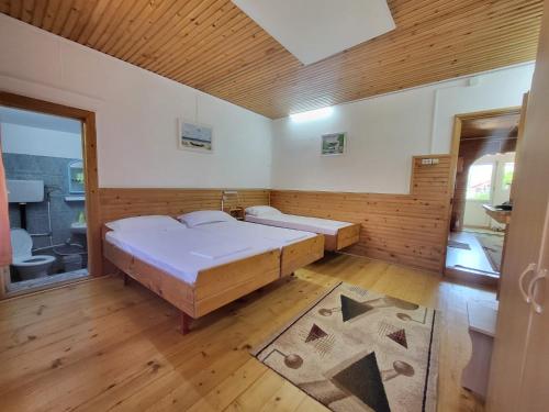 a bedroom with two beds in a room with wooden floors at Casa Ramona Sulina in Sulina