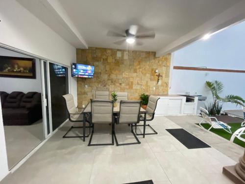 a dining room and living room with a table and chairs at Casa Chuy pueblo mágico in Xochitepec