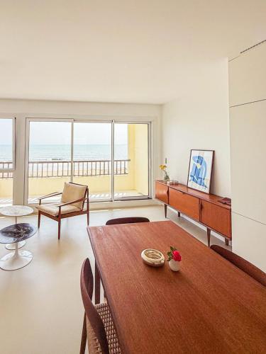 - un salon avec une table et une vue sur l'océan dans l'établissement Front de mer, confort et élégant, à Saint-Jean-de-Monts