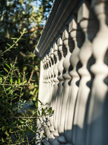a white fence with trees in the background at Areti Orfeas Studios in Vasilikos