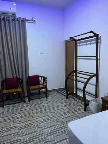 a bedroom with a bed and two chairs in a room at Luma Residence Anuradhapura in Anuradhapura