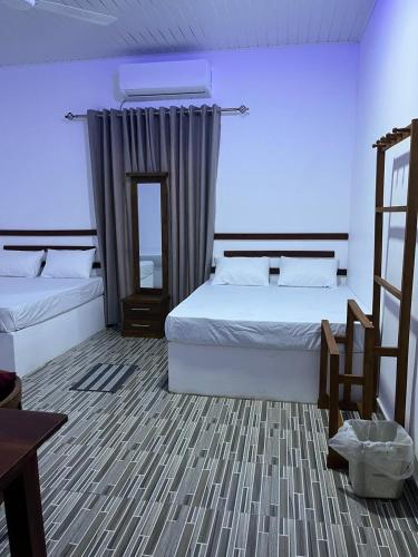 a bedroom with two beds and a mirror at Luma Residence Anuradhapura in Anuradhapura