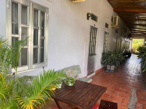patio con tavolo in legno e alcune piante di Hoài Oanh homestay a Mui Ne