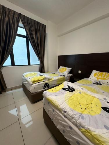 a bedroom with two beds with yellow and white sheets at Homestay in Marina Heights with beach view in Lumut