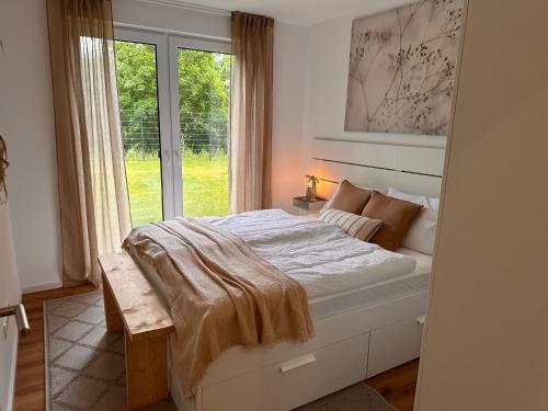 a bedroom with a large bed with a window at Naturblick & Sauna in der Eifel in Bad Münstereifel