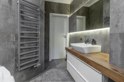 a bathroom with a sink and a mirror at Zabrska 18 Spacious Apartment by BookingHost in Katowice