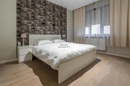 a bedroom with a bed and a brick wall at Zabrska 18 Spacious Apartment by BookingHost in Katowice
