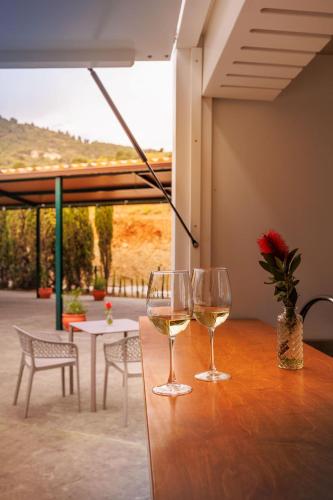 two glasses of white wine sitting on a wooden table at Apiedesierra - Caserio del Colmenar in Huétor Santillán