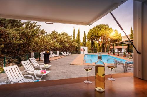 a bottle of wine on a table next to a pool at Apiedesierra - Caserio del Colmenar in Huétor Santillán