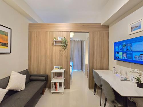 a living room with a couch and a table at 1BR Condotel with Balcony at FAME Residences #FM58-1 in Manila