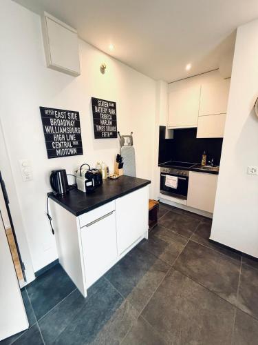 シャフハウゼンにあるThe R Apartment Weinsteig, comfort and serenityのキッチン(白いキャビネット、黒いカウンタートップ付)