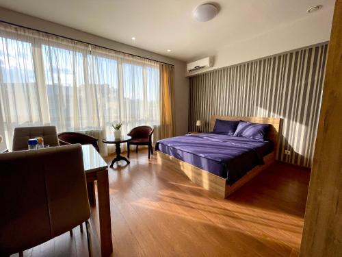 a bedroom with a bed and a table and a room at Apartment in Yerevan City Center Republic Square Self Check-In in Yerevan