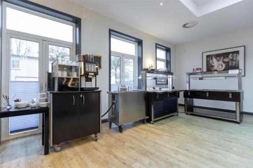 a large room with a kitchen with windows at Best Western Plus Theodor Storm Hotel in Husum
