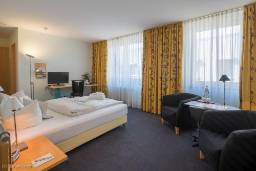a hotel room with a bed and a desk at Best Western Hotel im Forum Mülheim in Mülheim an der Ruhr