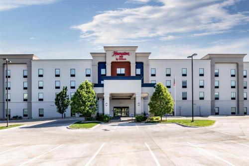 a white building with a red cross on the front at Hampton Inn Omaha/West Dodge Road, Old Mill in Omaha